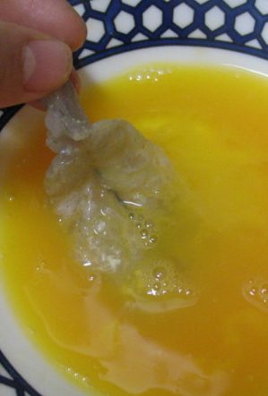韩式煎虾饼,将沾过莜面都虾均匀都裹一层蛋液。