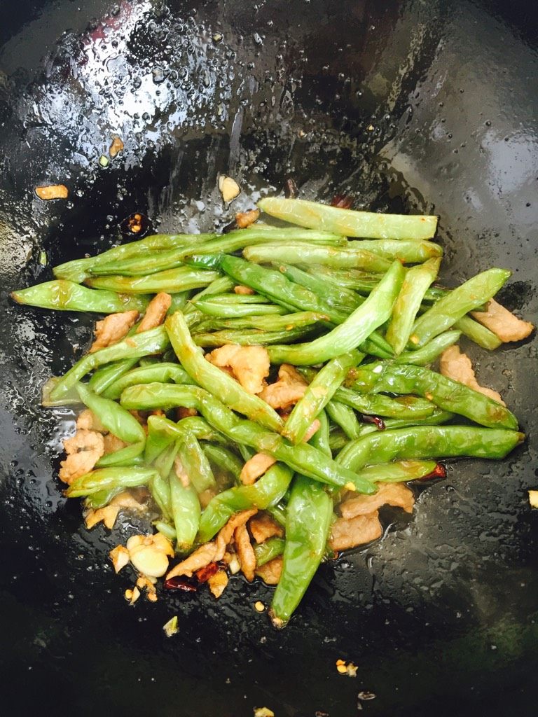 干煸豆角,再把炸好的豆角倒进去翻炒，加盐，少许料酒