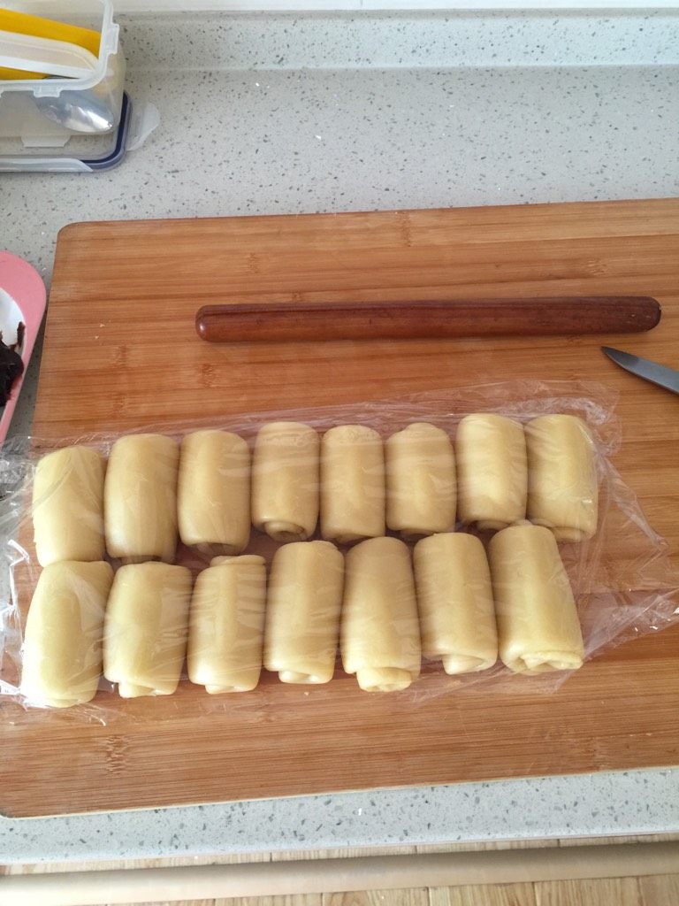 开口酥,醒好的的面皮分成等份，水油皮包裹油皮，捏成团，擀成牛舌状卷成卷