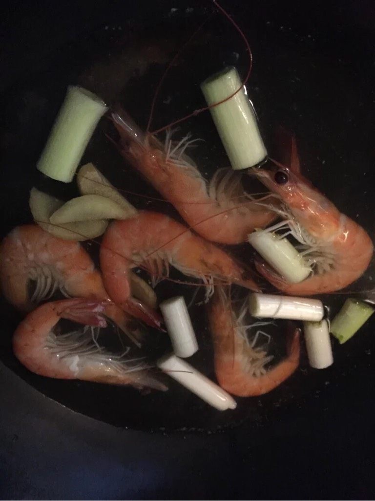 石锅拌饭,如图热锅冷油,油热加入葱花,加入少许盐将大虾炒至完全变成红色盛出备用