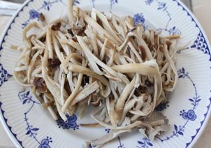 茶树菇炒茼蒿,焯好的茶树菇,用力挤出多余的水份,备用。