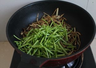 茶树菇炒茼蒿,放入茼蒿,快速翻炒,茼蒿变翠绿色即可。