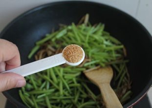 茶树菇炒茼蒿,立即放入鸡精调味,出锅。