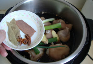香辣烤猪蹄,放入猪蹄、<a style='color:red;display:inline-block;' href='/shicai/ 710'>桂皮</a>、<a style='color:red;display:inline-block;' href='/shicai/ 741'>香叶</a>、<a style='color:red;display:inline-block;' href='/shicai/ 695'>八角</a>、葱姜，压制15分钟，拔掉电源焖至自然放气