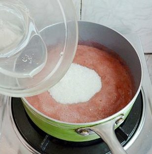 法式草莓软糖,草莓果泥倒入锅里小火加热至微温约40度时,往里拌入苹果胶白糖混合物,轻搅融化。