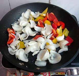 百合彩色培根,平底锅留底油，放入培百合和红、黄甜椒翻炒一小会，调入适量的盐，翻炒均匀。