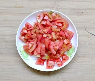 番茄酱焖排骨,趁着炖排骨的时间,我们将番茄放进碗里,加入开水泡2分钟,就可以轻易的将番茄的皮剥下来,然后将去皮的番茄切小粒备用。