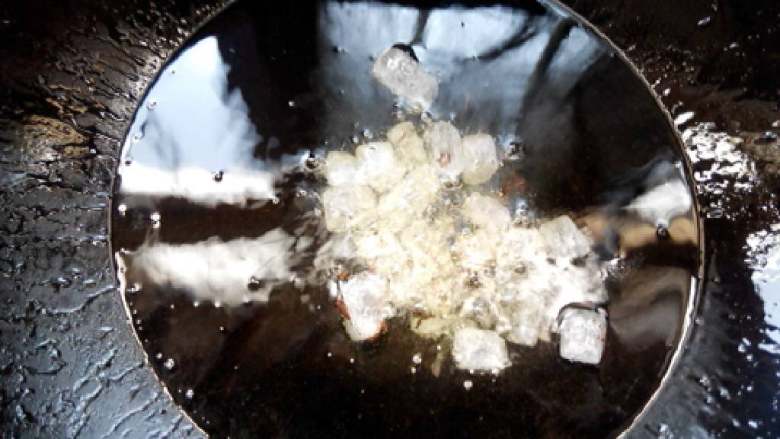 红酒五花肉,锅中倒入油，放入冰糖小火炒融化，炒至呈棕红色。