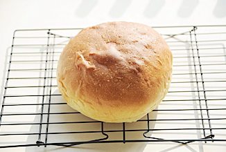 奶酪包,烤箱预热180℃,下层烘烤40分钟,中层加盖锡纸防止面包上色过重,烤好后取出趁热在面包表面刷上一层黄油,并将面包移入烤网晾凉;