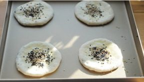 红糖空心烧饼,将圆饼表面刷蛋黄液,撒芝麻;