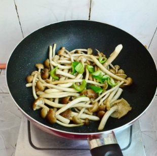 茶树菇香爆鸡块,利用煎出来的油,放入茶树菇翻炒至茶树菇变软出水,再放入青椒块,翻炒片刻至茶树菇的水份蒸发。