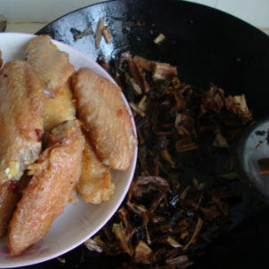 梅菜烧鸡翅,放入鸡翅，加<a style='color:red;display:inline-block;' href='/shicai/ 762'>老抽</a>、<a style='color:red;display:inline-block;' href='/shicai/ 788'>生抽</a>、料酒、胡椒粉炒匀，加水煮开