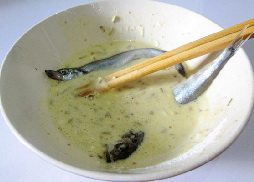 酥香多春鱼,将腌制好的多春鱼放入煎炸糊中有,沾满粉糊。