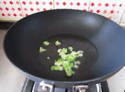 彩椒烩千张,另起锅,注入油爆香葱碎。