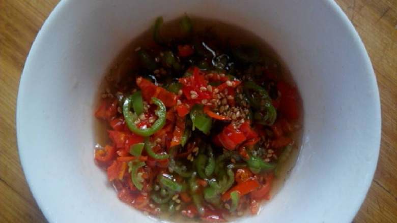 凉拌黄瓜火腿卷,青红辣椒放碗里，加上<a style='color:red;display:inline-block;' href='/shicai/ 678'>白芝麻</a>，热油烧热，迅速泼在碗里。