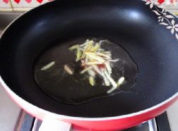 葱爆大虾,锅中注入油,下入姜丝爆香。
