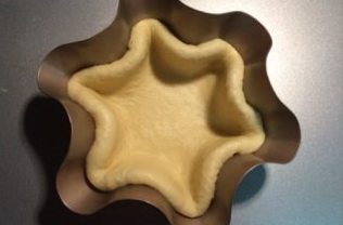 雪花黄桃,将面片放置在模具里,注意面片的大小不要将模具覆盖满,整理好凹凸不平的地方使面片与模具贴合