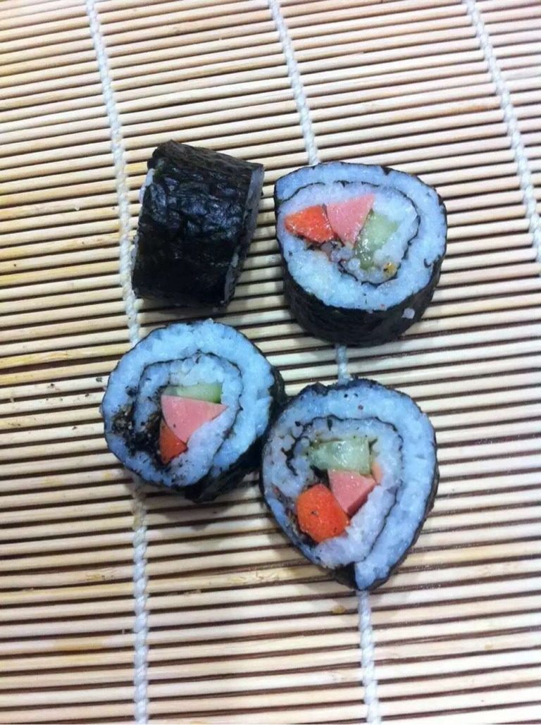 香丁寿司,先把竹签放平先铺好紫菜 再加入米饭铺平加黄瓜 胡萝卜 丁香鱼 香肠即可