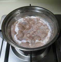 菊花纸杯蛋糕,小锅内放入牛奶煮至快要沸腾,加入掰成小块的巧克力,搅拌至巧克力融化,和牛奶充分混合均匀,关火放置一旁备用。