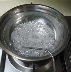 菊花纸杯蛋糕,水和细砂糖混合,放在火上煮开。糖融化。