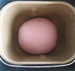 紫薯红豆沙吐司,揉好的面滚圆,放入面包桶内。