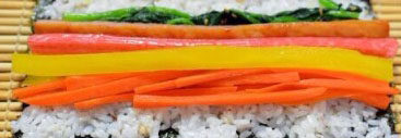 韩式紫菜包饭,纸板上放上紫菜，把<a style='color:red;display:inline-block;' href='/shicai/ 507'>米饭</a>均匀平铺。再放上准备好的所有食材