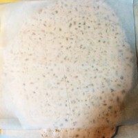 手工牛轧糖,拿出后放到铺了油纸的案板上,上面再盖一层油纸用擀面杖快速擀平至想要的厚度(放到不沾烤盘里也可以)。