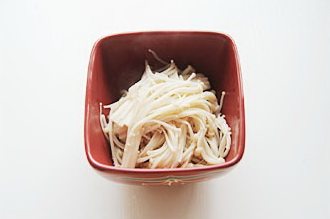 酸汤肥牛,锅内烧开水,加入盐放入金针菇煮开,保持沸腾1分钟,捞出控水铺在碗底;