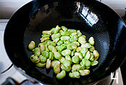 腊肠蒸蚕豆,蚕豆入油锅略炒,加半茶匙盐以及一点点糖炒匀,并加少许水翻炒均匀。(蚕豆比较吸水,加点水口感会更好)