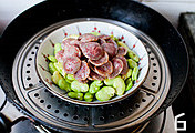 腊肠蒸蚕豆,炒好的蚕豆铺在碗底,腊肠铺在上面,入锅蒸10分钟,出锅撒葱花