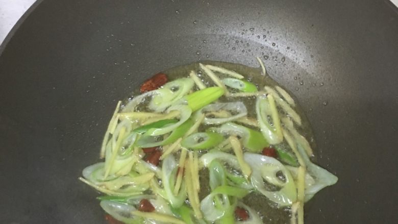 清炒花蛤,炒锅内油热后,倒入大葱、姜丝、干辣椒粒,爆香。