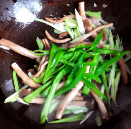 煸炒茶树菇,放入西芹丝翻炒几下