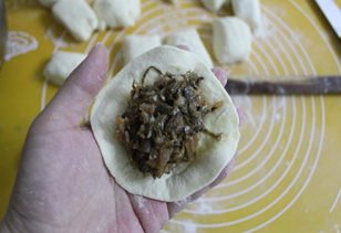 梅干菜包子,擀成包子皮,包上馅料。