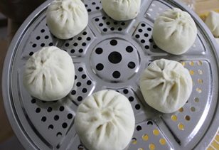 梅干菜包子,放入蒸锅,醒发15分钟,在烧水,水开蒸15分钟,关火闷5分钟在开盖取出。