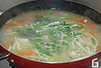 蔬果炖鲫鱼,加入海鲜菇和芦笋并加盐调味,稍煮后关火撒入青蒜末