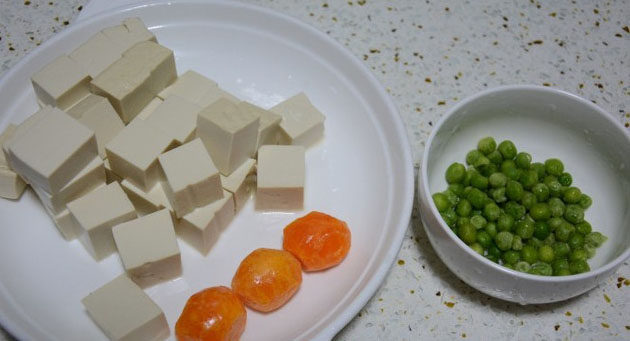 懒人蟹黄豆腐,将豆腐用淡盐水侵泡10分钟后切成小块,<a style='color:red;display:inline-block;' href='/shicai/ 148'>豌豆</a>洗净,咸鸭蛋煮好后只留蛋黄部分