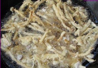 椒盐茶树菇,起火上锅倒进色拉油,油温升至6成左右把挂上面糊的茶树菇一根一根放进锅内,期间油温偏高可以适当把火力调小,炸制金黄色外酥里嫩出锅沥油,洒点葱花与椒盐拌匀。