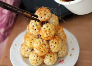 绣球塔,然后用两根筷子挑起糖浆,在绣球塔的表面拉丝即可!