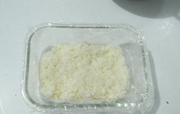 粢饭糕,拌好盐的米饭放入容器,用勺压实,拍紧