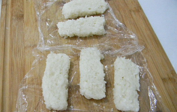 粢饭糕,拌好盐的米饭放入容器,用勺压实,拍紧