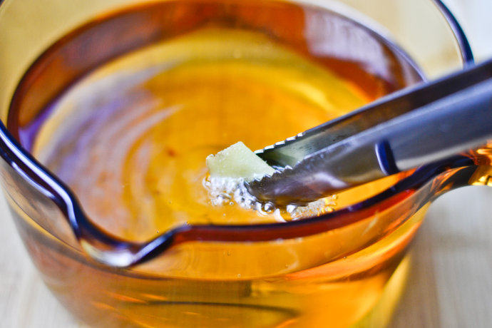 炸鸡块配酸奶酱,取一深锅，锅不要用太大，选用酱汁锅较好
这样可以节省油的用量也防止喷溅，又能保证鸡肉炸得均匀
倒入适量油，加热，用姜片放在油中立即冒泡时即可