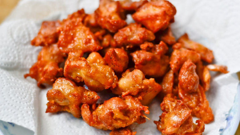 炸鸡块配酸奶酱,待锅中油稍微有点冒小烟时，迅速将初炸过的鸡块入锅进行复炸，大约10秒左右即可捞出，控干油份后放在吸油纸上，吸去多余油份