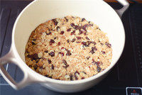 圣诞布丁,倒入面包果仁里拌匀。陶瓷锅内壁涂黄油，撒砂糖防粘。入锅，压实。