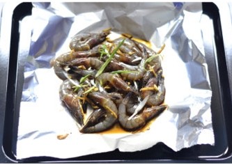 锡纸包虾,均匀地撒上葱丝,喜欢口味浓些的也可以再撒些蒜末等