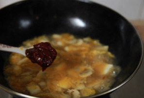 韩式泡菜海鲜锅,取一炒锅，放油烧热，爆香蒜蓉，接着放入<a style='color:red;display:inline-block;' href='/shicai/ 698'>泡菜</a>翻炒约1分钟，倒入刚才氽蛤蜊的原汤，放入蘑菇烧开；烧开后放入<a style='color:red;display:inline-block;' href='/shicai/ 465'>豆腐</a>，小心的翻动以免<a style='color:red;display:inline-block;' href='/shicai/ 465'>豆腐</a>碎掉，调入2汤匙<a style='color:red;display:inline-block;' href='/shicai/ 4510'>黄豆酱</a>，1汤匙左右<a style='color:red;display:inline-block;' href='/shicai/ 8426'>韩式辣酱</a>（不喜吃辣可以不放，量随自己口味增减），再尝尝咸淡，适当放盐。