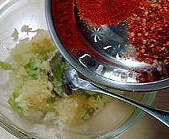 韩国腌黄瓜,把捣好的蒜蓉、姜蓉和苹果蓉倒入料理盆,里面放入干辣椒粉和干辣椒碎