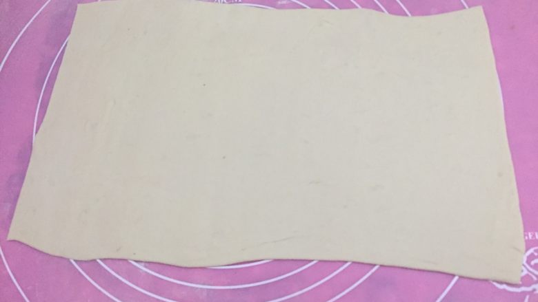 肉龙,如图发酵好的面团充分排气,分成均匀的四份,取其中一份擀成长圆形,可以把两边的圆形切掉,就成了一个长方形(传统的面皮会很厚,我做的比较薄,大概比饺子皮稍厚一点。)