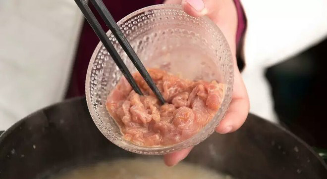 铸铁锅版皮蛋瘦肉粥,撒入待用的肉丝搅拌,最小火焖煮2分钟后,关火3分钟,撒上香葱就可以出锅了