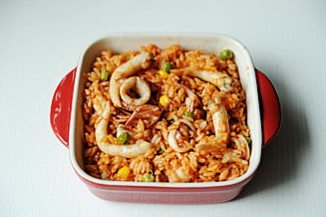 芝士焗海鲜饭,将炒好的海鲜饭装入烤盘中;