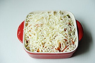 芝士焗海鲜饭,将马苏里拉奶酪铺在海鲜饭的上面,喜欢多奶酪的多铺,喜欢少的少铺,最好是能覆盖整个碗顶,烤箱180℃,中层烘烤15分钟,奶酪融化即可。